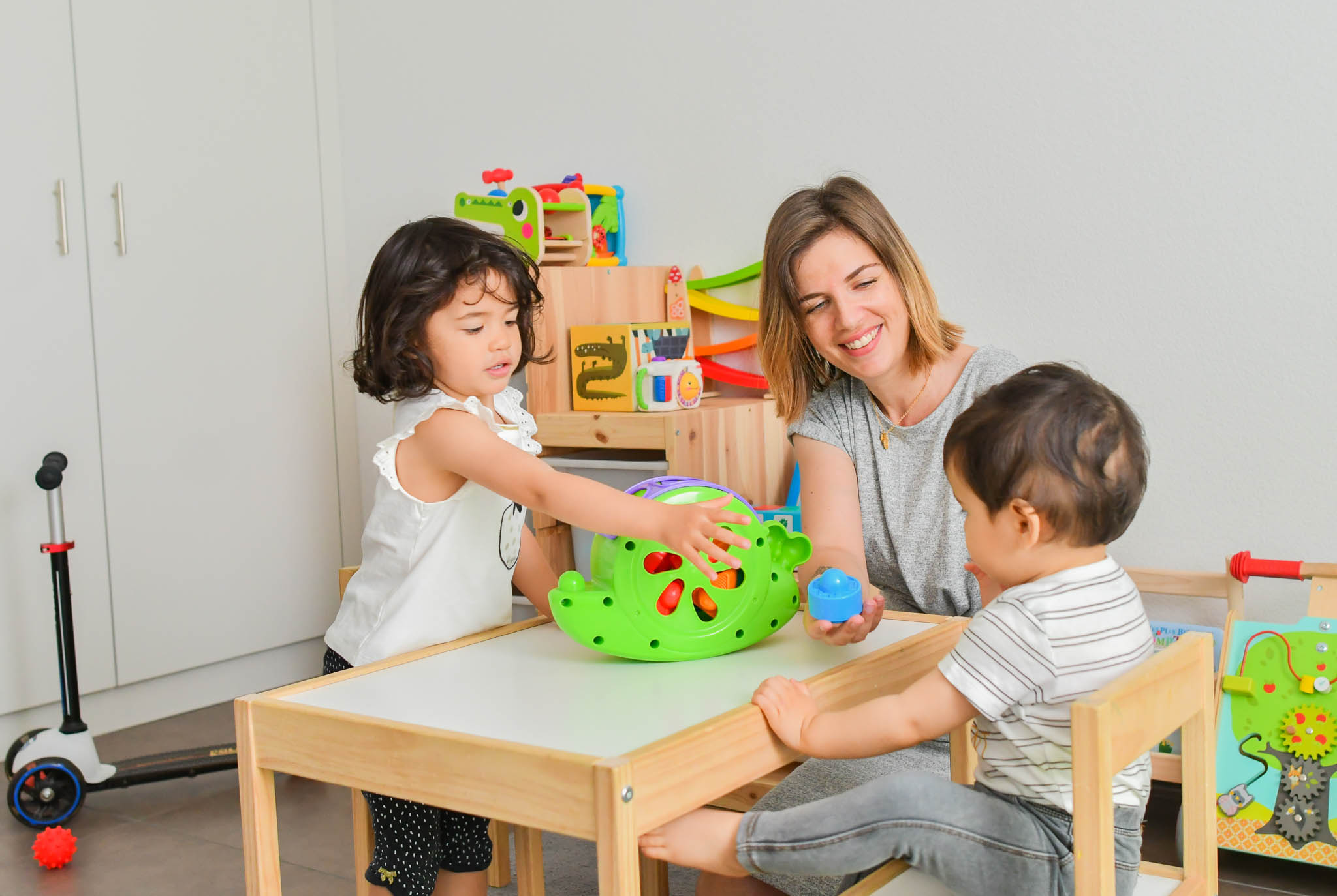 Enfants jouant dans leur chambre avec leur maman.