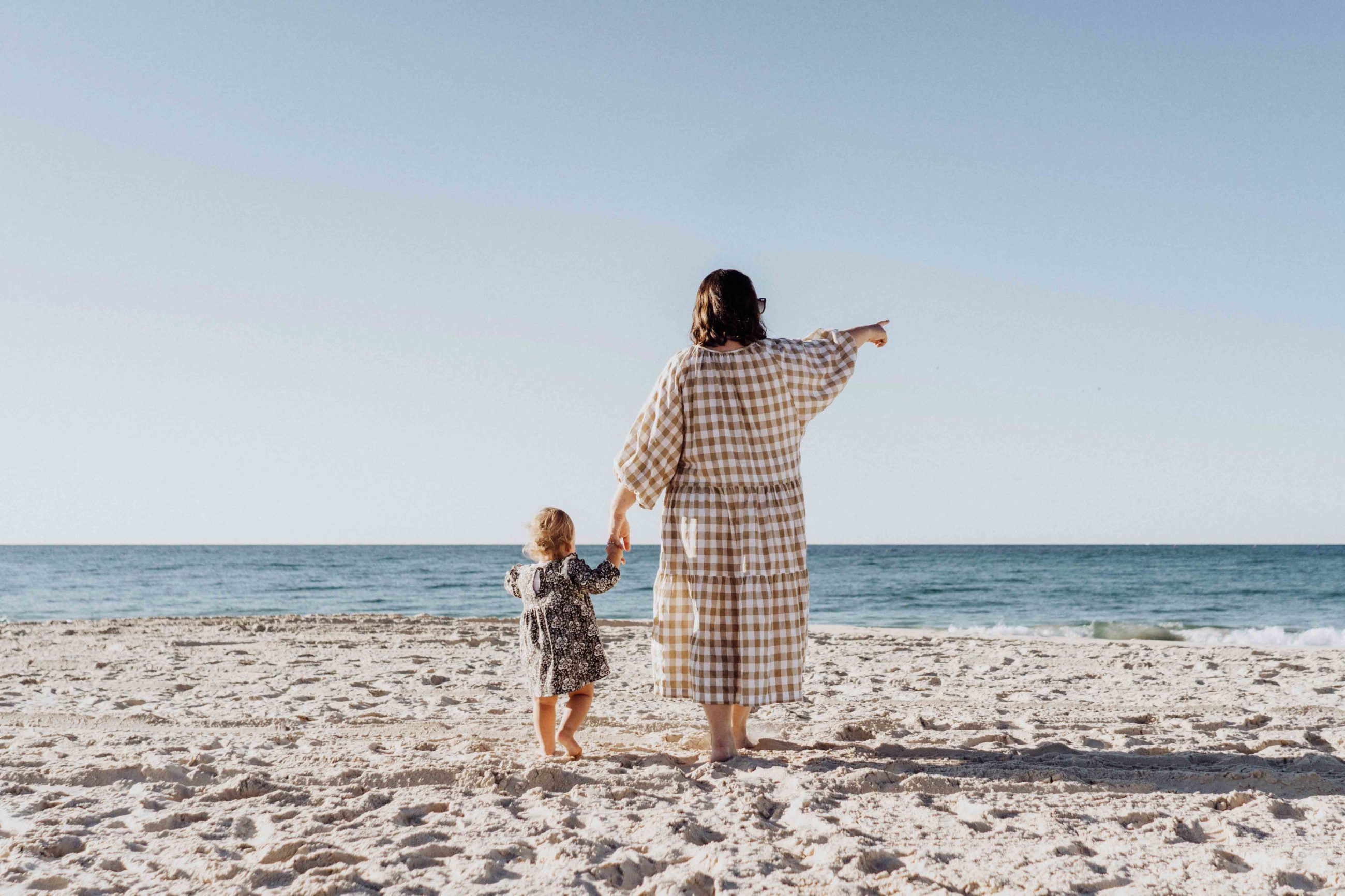 Mère et fille qui regardent l'horizon sur la plage